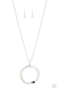 An airy, oversized, warped, shiny silver hoop dangles down the chest from a classic silver chain. Two rows of dainty iridescent rhinestones encrust along the inner curve of the hoop for an understated, elegant dazzle. Features an adjustable clasp closure. 