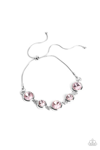 Varying sizes of classic, round, brilliant-cut pink rhinestones set in thick, circular, silver frames link together around the wrist with glamorous glimmer. The rhinestones attach to a dainty strand of silver snake chain that wraps around the wrist in a refined finish. Features an adjustable lariat sliding bead closure. 