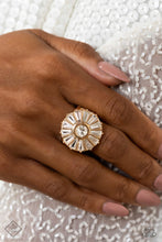 Load image into Gallery viewer, Featuring pronged gold fittings, an explosion of glassy, white, emerald-cut gems fan out from a faceted, round white gem for a sparkly centerpiece atop the finger. Gold bands arc across the finger in the background, prominently showcasing the dramatic design. Features a stretchy band for a flexible fit.  Sold as one individual ring.
