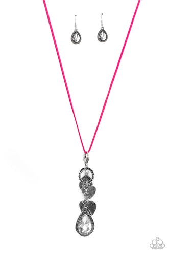  Dangling from the bottom of an elongated pink suede string, a lobster clasp closure holds an eclectic collection of shimmer and shine. Featured on the lobster clasp, varying sizes of white teardrop gems pressed into silver studded frames, varying sizes of silver hearts brushed in an antiqued pattern, and a ring brushed in a cobblestone-like pattern create a whimsical refinement down the neckline. Features an adjustable clasp closure.