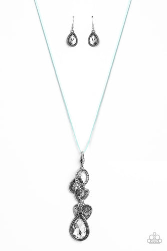 Dangling from the bottom of an elongated aqua suede string, a lobster clasp closure holds an eclectic collection of shimmer and shine. Featured on the lobster clasp, varying sizes of white teardrop gems pressed into silver studded frames, varying sizes of silver hearts brushed in an antiqued pattern, and a ring brushed in a cobblestone-like pattern create a whimsical refinement down the neckline. Features an adjustable clasp closure.
