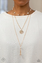 Load image into Gallery viewer, Three shimmery gold chains layer across the chest, with each strand featuring a different motif. Featured on the uppermost chain, white baroque pearls sporadically dot a dainty gold chain. Below it, a gold paperclip chain emerges, with a circular pendant adorned in a classy collection of emerald-cut white gem bars fanning out from a white rhinestone center. Finally, on the lowermost layer, baroque pearls drip into a flirtatious tassel, infusing the design with subtle movement.
