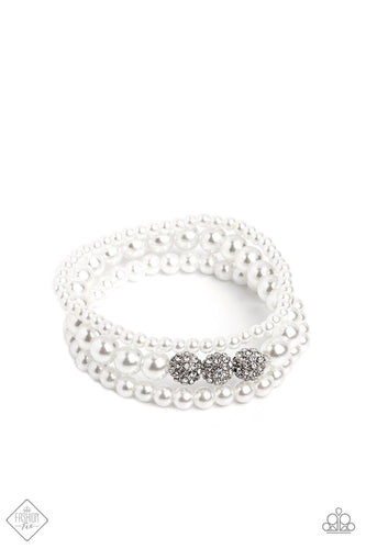 Three strands of classic white pearls, each in varying sizes, coalesce around the wrist on elastic stretchy bands into a feminine display. A trio of rhinestone-encrusted spheres dots the largest strand of pearls, infusing the design with capricious shimmer.  Sold as one set of three bracelets.  New Kit Fashion Fix