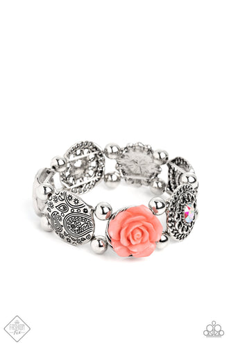 Whimsically woven around the wrist on elastic stretchy bands, a coral resin rose, a silver disc stamped with a paisley motif, an oversized iridescent gem with an orange undertone encased in a textured silver frame, an airy, textured wheel pendant with an iridescent center, a pearl-centered flower with Peach Pink gem petals, and a disc featuring a metallic rose, create a beautifully botanical design.