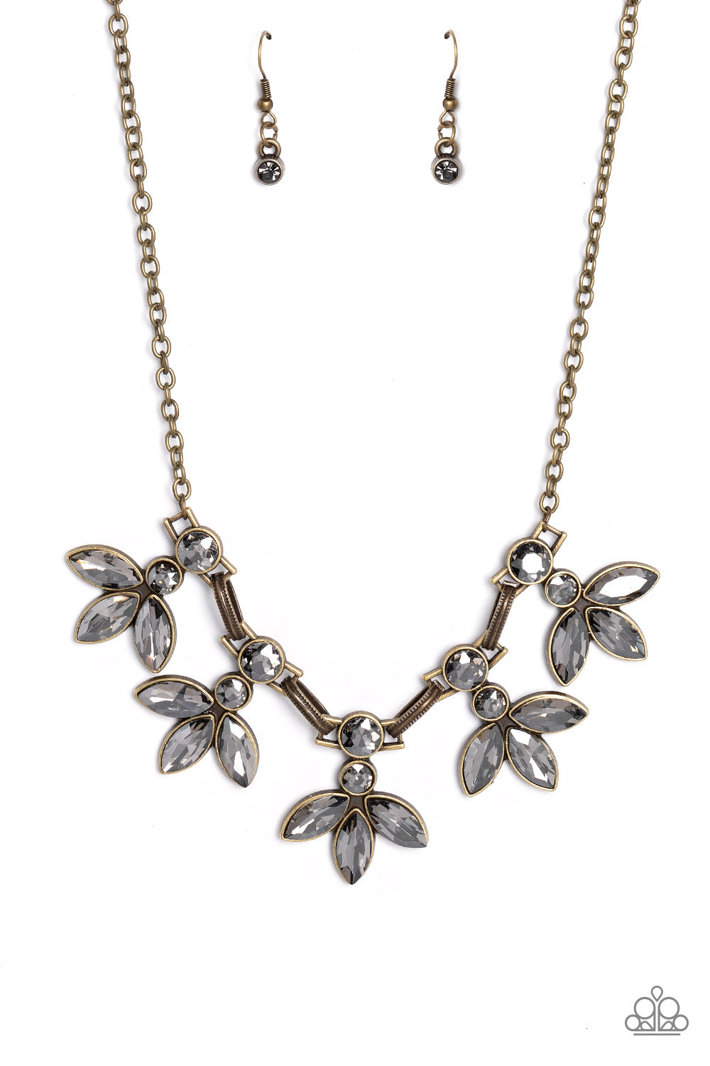 Featuring smoldering marquise style cuts, oversized smoky gems fan out from an interconnected, circular smoky rhinestone display. Separating the dauntless florals, airy brass ovals, stamped with a dot motif, create additional eye-catching sheen. Features an adjustable clasp closure.