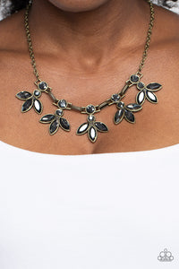 Featuring smoldering marquise style cuts, oversized smoky gems fan out from an interconnected, circular smoky rhinestone display. Separating the dauntless florals, airy brass ovals, stamped with a dot motif, create additional eye-catching sheen. Features an adjustable clasp closure.