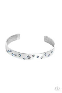 Tinted in subtle, stellar shades of blue and iridescence, dainty rhinestones are pressed into the centers of stamped stars in varying sizes. Embossed in tactile textures, the starry collection wraps around the wrist against a backdrop of a high-sheen silver cuff, emitting further glow to the design. Due to its prismatic palette, color may vary.