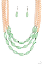 Load image into Gallery viewer, Shiny silver cubed accents, cloudy, milky, green oval beads and milky peach beads coalesce down the neckline on invisible wires, creating a trio of colorful layers. Features an adjustable clasp closure.
