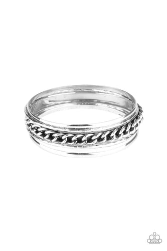 Pairs of smooth and textured silver bangles join an antiqued bangle around the wrist that is decorated in a single strand of silver chain for a gritty finish.