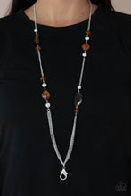 Load image into Gallery viewer, An earthy collection of speckled and marbled funky shaped brown acrylic beads mixed with shiny silver beads take turns climbing a silver chain. A triple set of silver chain connects across the bottom creating a noteworthy finish. A lobster clasp hangs from the bottom of the design to allow a name badge or other item to be attached. Features an adjustable clasp closure.  Sold as one individual lanyard. Includes one pair of matching earrings.
