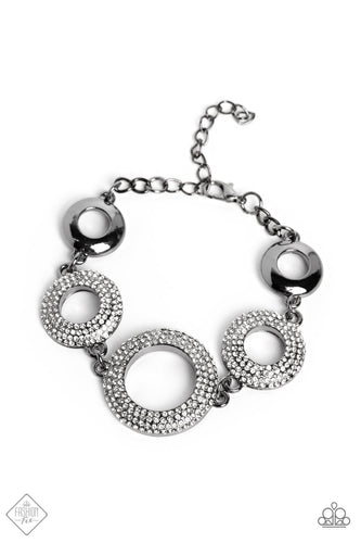 A pair of high-sheen gunmetal hoops flank a trio of larger gunmetal hoops covered in white rhinestones. Each ring features beveled surfaces, which amplify the dramatic sparkle and sheen they radiate. Features an adjustable clasp closure.  Sold as one individual bracelet.