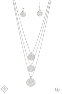 Three silver discs trickle from the bottom of three silver snake chains, creating shimmery monochromatic layers down the chest. An intricate floral design is stamped onto each disc, adding a whimsical touch to the charming design. Features an adjustable clasp closure.  Sold as one individual necklace. Includes one pair of matching earrings.
