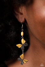 Load image into Gallery viewer, Two butterflies, with wings of silver filigree, and yellow stones, flutter below an oval yellow stone, creating a free-spirited lure. Each butterfly swings in whimsical asymmetry, creating the look of butterflies flying in alternating directions. Earring attaches to a standard fishhook fitting. As the stone elements in this piece are natural, some color variation is normal. 
