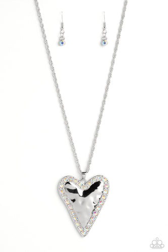 Hammered in antiqued texture, an oversized, abstract silver heart swings from the bottom of a silver chain for a whimsical look. Silver studs and glittery iridescent gems border the hammered texture for a touch of bling. Features an adjustable clasp closure. Due to its prismatic palette, color may vary. 