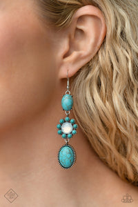 A trio of earthy turquoise stones is linked together as they fall from the ear. An oval-cut turquoise stone with a pronged silver frame anchors the cascade, followed by a round-cut opalescent bead bordered in turquoise beads. Another oval-cut turquoise stone in a studded frame finishes off the design, swaying effortlessly from the ear in a whimsical finish. Earring attaches to a standard fishhook fitting. As the stone elements in this piece are natural, some color variation is normal.