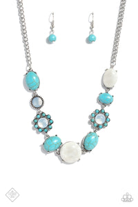 A collection of turquoise stones and white opalescent beads are featured in a range of pronged silver fittings and floral patterns, falling along the neckline in an artisanal display. The haphazard placement of each element further emphasizes their handcrafted charm, as the opalescent beads bring a hint of shimmer to the design. Features an adjustable clasp closure. As the stone elements in this piece are natural, some color variation is normal.