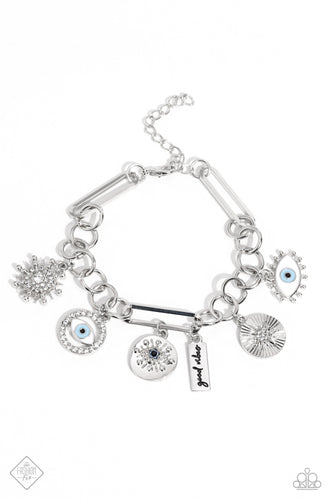A harmonious compilation of charms, featuring tranquil shades of blue and accents of black, wrap around the wrist on a handcrafted chain. Elongated paperclip links and oversized jump rings interlock in a homespun fashion, showcasing the variety of charms that include a rhinestone-dusted sunburst and sunburst pendant, an eye with tactile silver eyelashes, a rectangular pendant stamped with the phrase 