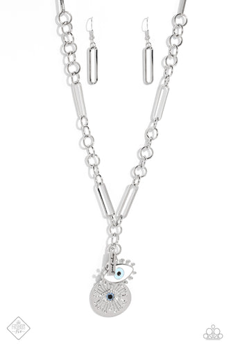 A harmonious compilation of charms, featuring tranquil shades of blue and accents of black, gather at the bottom of a handcrafted chain. Elongated paperclip links and oversized jump rings interlock as they fall down the neckline, leading to the boisterous collection of charms, which include a rectangular silver plate stamped with the phrase, 