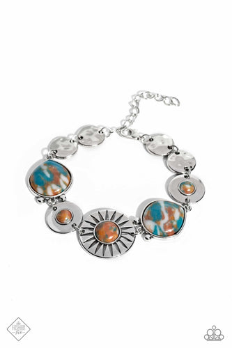 A collection of round and teardrop-shaped stones, marbled with swirls of brown, blue, and white, are pressed into silver frames before linking around the wrist. Textured silver discs round out the design, complementing the textures etched throughout the remaining frames. Features an adjustable clasp closure. As the stone elements in this piece are natural, some color variation is normal.  Sold as one individual bracelet.