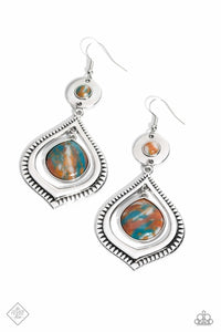 A brown stone marbled with blue and white is pressed into a thick circular silver frame. Dangling from the circular frame, an oversized silver spade-like frame etched in rural textures, features a larger brown stone marbled with blue and white, swinging from the top of the frame for an earthy lure. Earring attaches to a standard fishhook fitting. As the stone elements in this piece are natural, some color variation is normal.