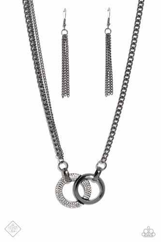 A pair of beveled gunmetal hoops interlock at the center of the collarbone, creating an eye-catching pendant. One hoop is coated in white rhinestones, while the other showcases a high-sheen finish, providing an intriguing collision of texture. The interlocking pendant is attached to a thick gunmetal chain, with a pair of daintier gunmetal chains added along one side for an asymmetrical finish. Features an adjustable clasp closure.  Sold as one individual necklace. Includes one pair of matching earrin