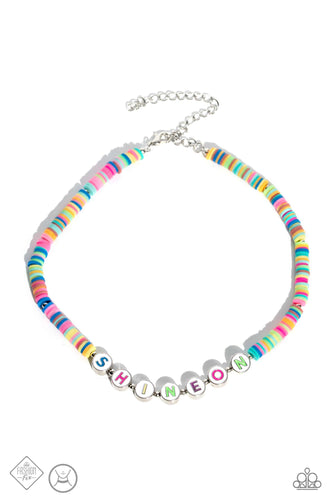 Countless clay discs in a kaleidoscope of color combine with subtle silver studs, stacking along an invisible wire to create a choker. Chunky white discs featuring multicolored letters spell out the phrase, 