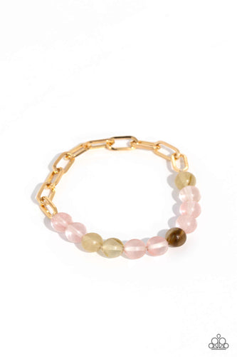 A strand of gold paperclip chain collides with glassy pink stone beads in various hues along a stretchy band to create a seasonally urban statement. As the stone elements in this piece are natural, some color variation is normal. 