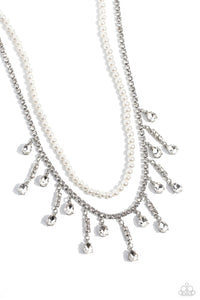 Featuring a white rhinestone square-fitting chain, white teardrop-cut gems, bordered in silver pronged fittings, swing from streams of glittery rhinestones while solitaire teardrop gems drip in an alternating pattern. A strand of gleaming white pearls layers above the silver display for a luxurious finish around the collar. Features an adjustable clasp closure. 