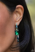 Load image into Gallery viewer, Encrusted in round and emerald-cut aquamarine and emerald gems, some featuring an iridescent sheen, an exaggerated oblong silver hoop curls around the ear, refracting light in a dramatic, knockout finish. Earring attaches to a standard post fitting. Hoop measures approximately 2&quot; long. Due to its prismatic palette, color may vary.
