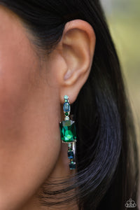 Encrusted in round and emerald-cut aquamarine and emerald gems, some featuring an iridescent sheen, an exaggerated oblong silver hoop curls around the ear, refracting light in a dramatic, knockout finish. Earring attaches to a standard post fitting. Hoop measures approximately 2" long. Due to its prismatic palette, color may vary.