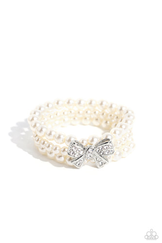 Strung along elastic stretchy bands, three strands of high-sheen classic white pearls wrap around the wrist. Featured atop the pearly collection, a loopy silver bow, filled with glistening white rhinestones is attached to the center of the wrist for a dramatically dazzling finish.