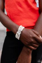 Load image into Gallery viewer, Strung along elastic stretchy bands, three strands of high-sheen classic white pearls wrap around the wrist. Featured atop the pearly collection, a loopy silver bow, filled with glistening white rhinestones is attached to the center of the wrist for a dramatically dazzling finish.
