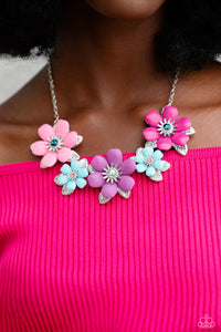 Dotted with dainty Harbor Blue, aquamarine, and rose rhinestone centers, dainty silver flowers bloom against a backdrop of glossy acrylic flowers in Aurora Pink, Rose Violet, Cattleya Orchid, and Spun Sugar hues. Each flower, varying in size, blossoms across a textured collection of silver leaves below the collar, invoking a festive spirit. Features an adjustable clasp closure.