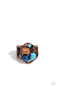 An earthy collection of tiger's eye, turquoise, marbled brown, and various blue stones are pressed into the center of an airy copper oval, for an earthy centerpiece. The oval display rests atop airy copper bands, further highlighting the earthy textures and sheens of the various stones. Features a stretchy band for a flexible fit. As the stone elements in this piece are natural, some color variation is normal.