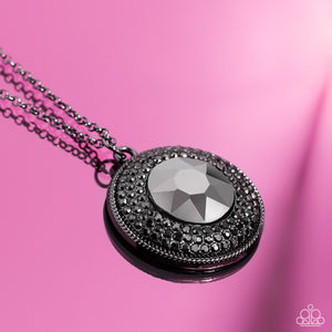 Sparkling with an oversized hematite center, a concaved gunmetal disc encompassing radiating rows of shimmering hematite rhinestones cascades from an elongated gunmetal chain, creating a striking impact. Features an adjustable clasp closure. 