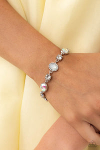 Featuring pronged silver fittings, white solitaire rhinestones alternate with oval opalescent and iridescent gems, linking around the wrist for a timeless, dreamy finish. Features an adjustable clasp closure. Due to its prismatic palette, color may vary. 