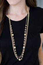 Load image into Gallery viewer, Infused with rows of shimmery gold chains, a strand of golden crystal-like beads and classic gold accents drape across the chest for a regal finish. Features an adjustable clasp closure.  Sold as one individual necklace. Includes one pair of matching earrings.
