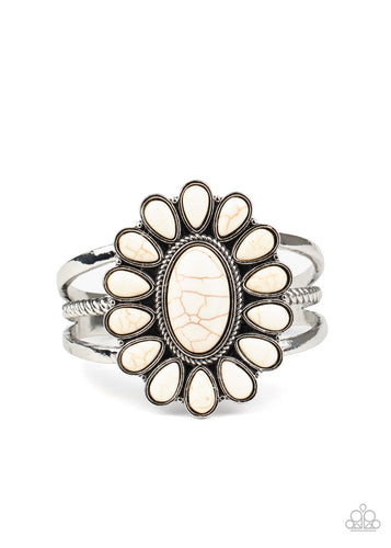 A white stone daisy frame blooms atop a mixed layered silver cuff, creating a whimsical centerpiece around the wrist.