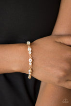 Load image into Gallery viewer, Varying in size, pairs of glassy white rhinestones are encrusted along glistening gold frames and linked around the wrist for a timeless finish. Features an adjustable clasp closure.
