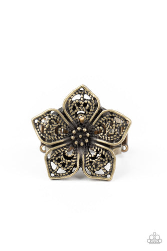 Brushed in an antiqued shimmer, lacy brass petals bloom from a studded center, creating a whimsical flower atop the finger. Features a stretchy band for a flexible fit.