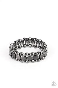 Glistening gunmetal disc fittings and pairs of classic gunmetal beads are threaded along stretchy bands around the wrist that connect into a bold industrial display around the wrist.  Sold as one individual bracelet.