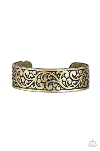 Brushed in an antiqued shimmer, vine-like filigree is embossed across the front of a thick brass cuff for a whimsical look.