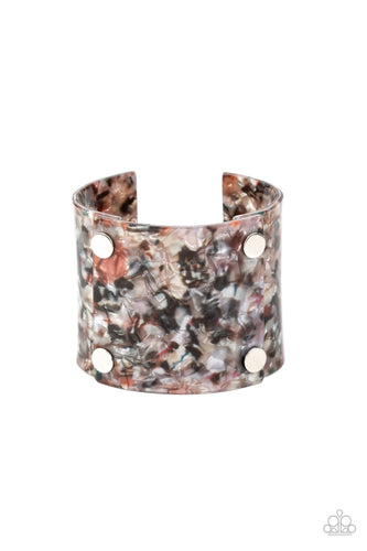 Featuring a shell-like finish, pieces of iridescent acrylic frames are bolted in place into a stylish cuff around the wrist.  Sold as one individual bracelet