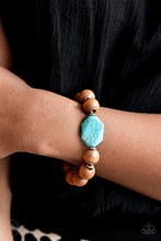 Load image into Gallery viewer, Oversized brown wooden beads and mismatched turquoise stone accents are separated by dainty silver discs and threaded along a stretchy band, creating an earthy centerpiece around the wrist.  Sold as one individual bracelet.  New Kit Fashion Fix
