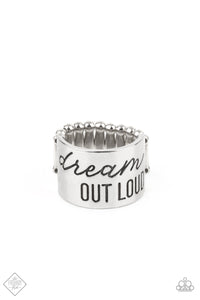 The front of a thick silver band is stamped in the phrase, "Dream out loud," creating an inspirational centerpiece across the finger. Features a stretchy band for a flexible fit.  Sold as one individual ring.