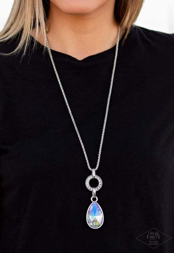 Encrusted in glittery white rhinestones, a shimmery silver ring gives way to a dramatic iridescent gem teardrop. The impressive pendant slides along a shimmery silver popcorn chain for a refined look. Features an adjustable clasp closure.  Sold as one individual necklace. Includes one pair of matching earrings.