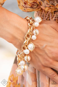 Classic white pearls and solitaire pearls that are threaded along a rod inside imperfect gold rings swing from a chunky double-linked gold chain around the wrist, creating a dramatic fringe. Features an adjustable clasp closure.  Sold as one individual bracelet.