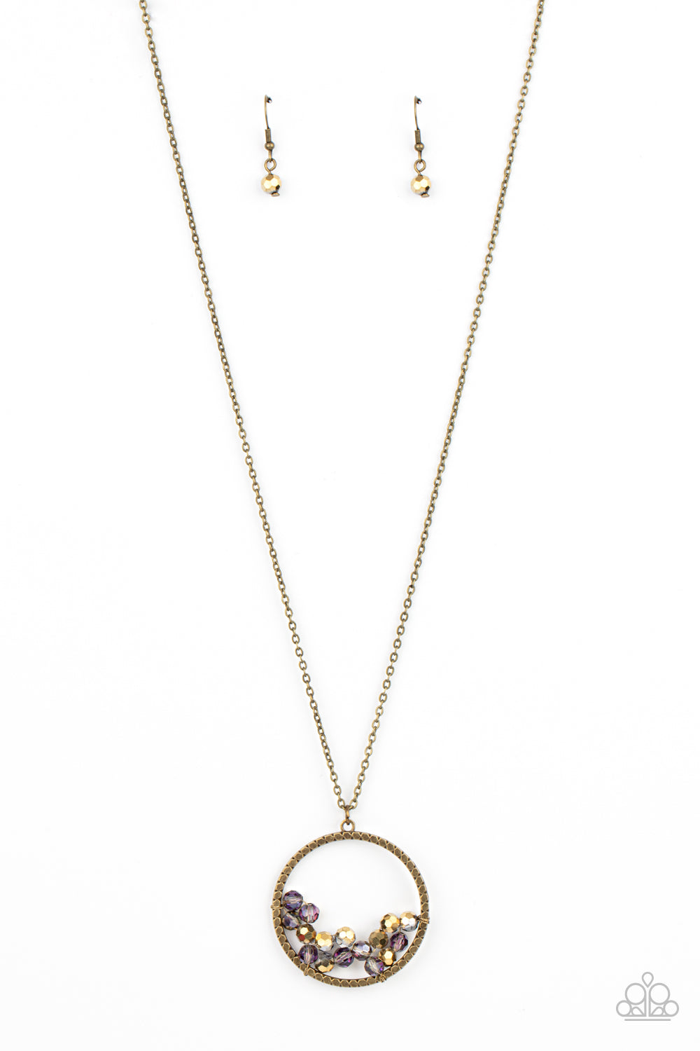 A cluster of metallic flecked aurum and iridescent crystal-like beads are threaded along dainty brass wire along the bottom of a textured brass hoop, creating a stellar pendant at the bottom of a lengthened brass chain. Features an adjustable clasp closure.  Sold as one individual necklace. Includes one pair of matching earrings.