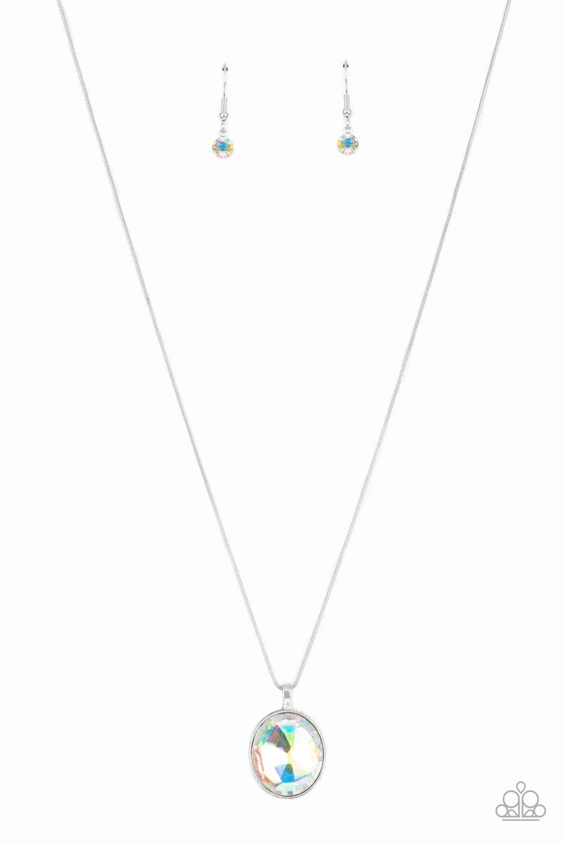 An oversized iridescent gem is pressed into the center of a sleek silver fitting, creating a mesmerizing statement piece at the bottom of a sleek silver chain. Features an adjustable clasp closure.  Sold as one individual necklace. Includes one pair of matching earrings.