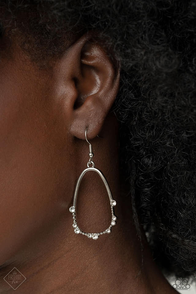 The bottom edge of an airy asymmetrical silver teardrop frame is studded and dotted in dainty white rhinestones, creating an elegant display. Earring attaches to a standard fishhook fitting.  Sold as one pair of earrings.